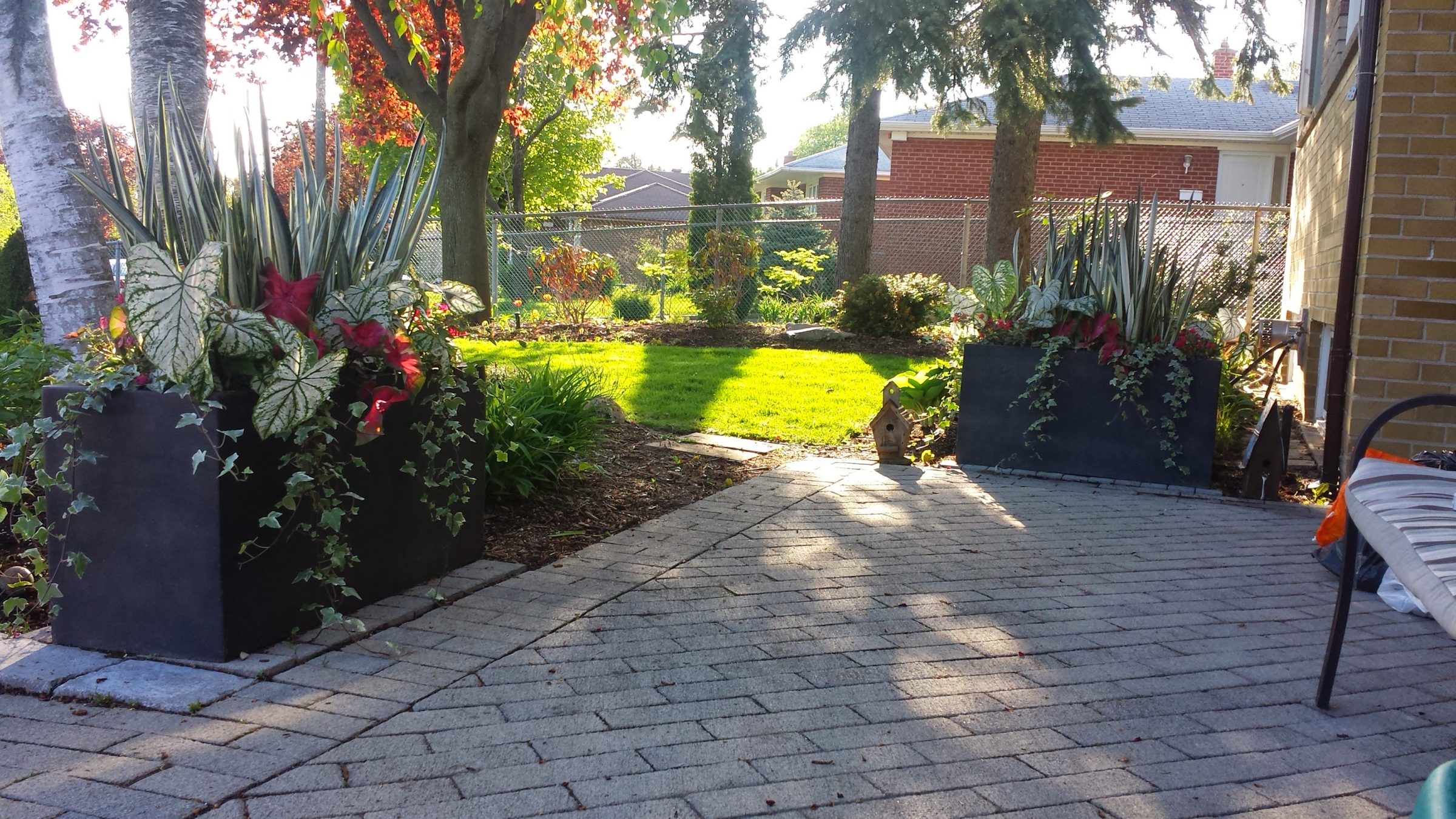Lush garden with modern planters and sunlight.