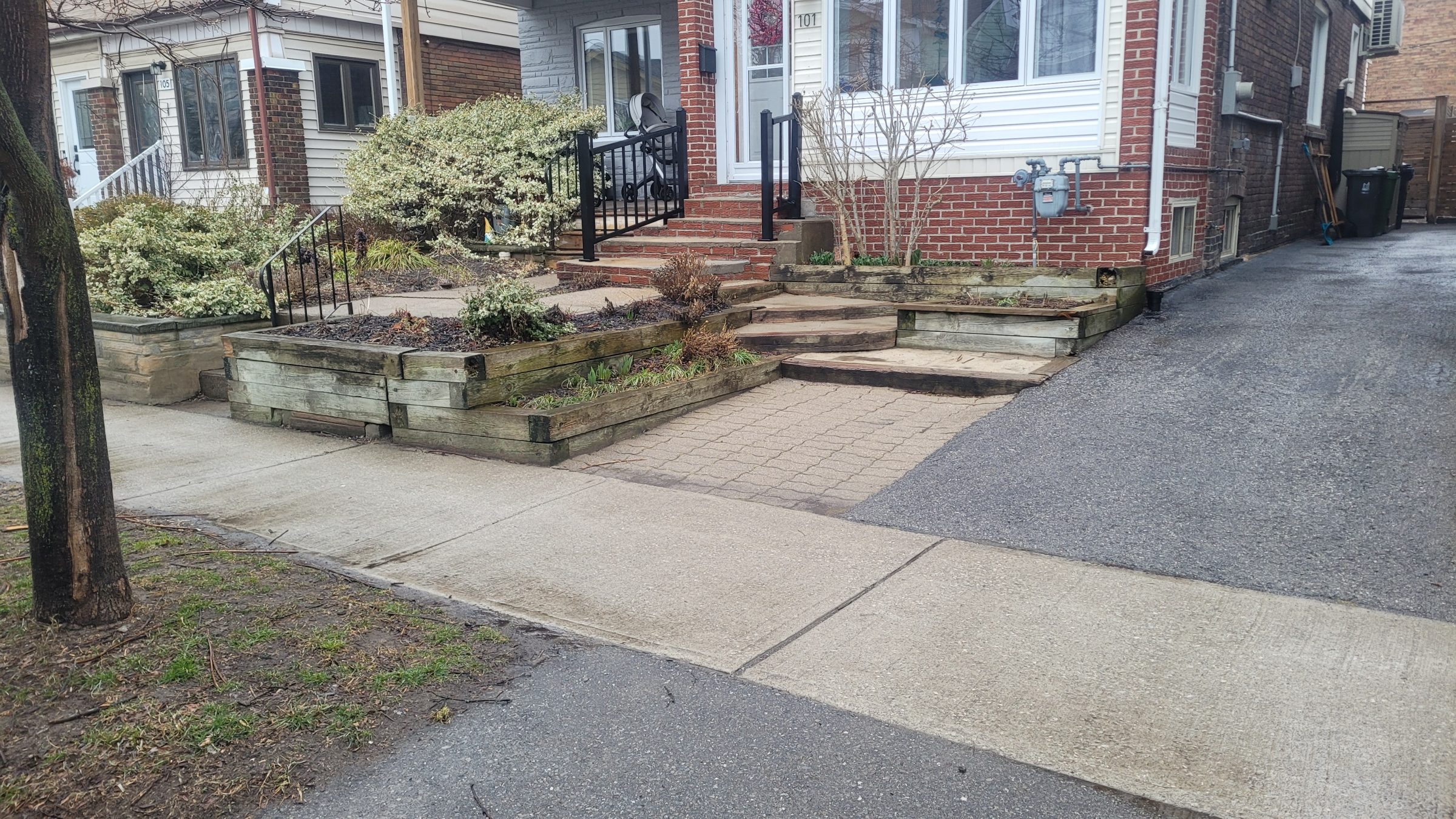 Residential entrance with steps and garden beds.