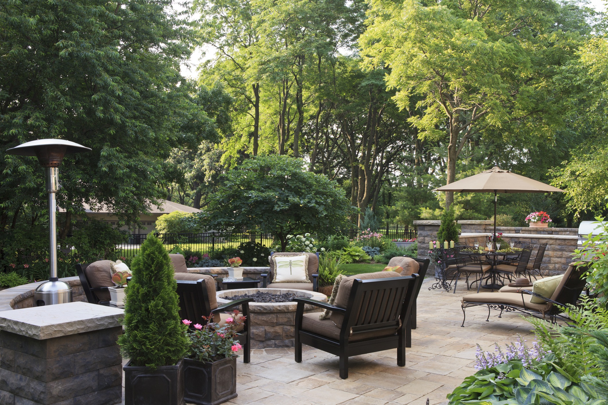 Backyard patio with seating and lush greenery.