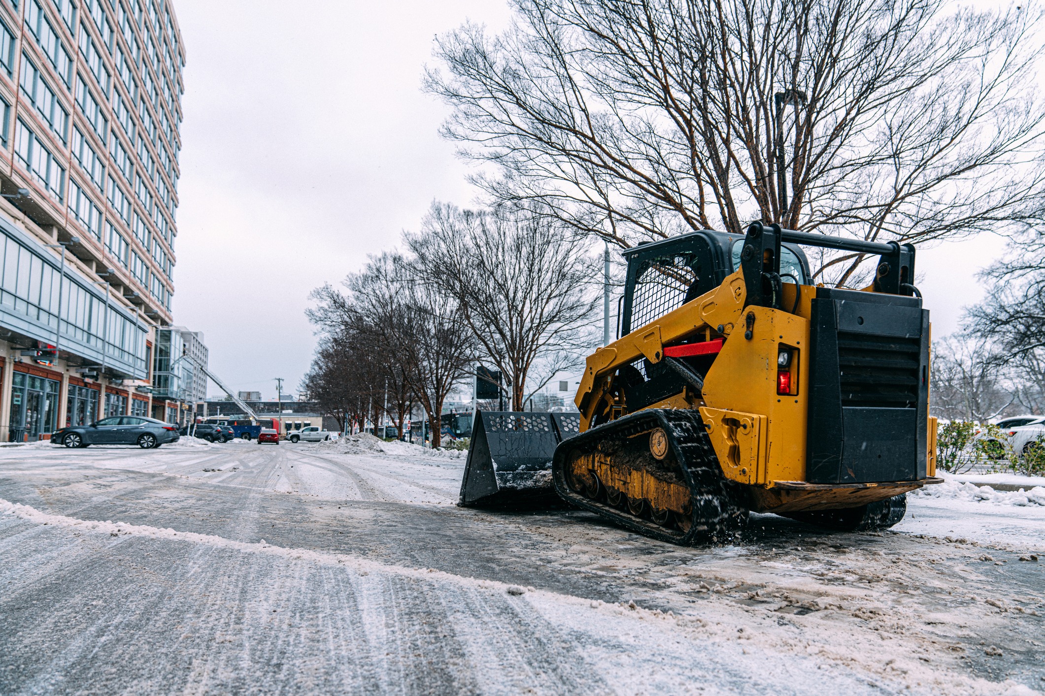 Snowplow clearing snowy urban street