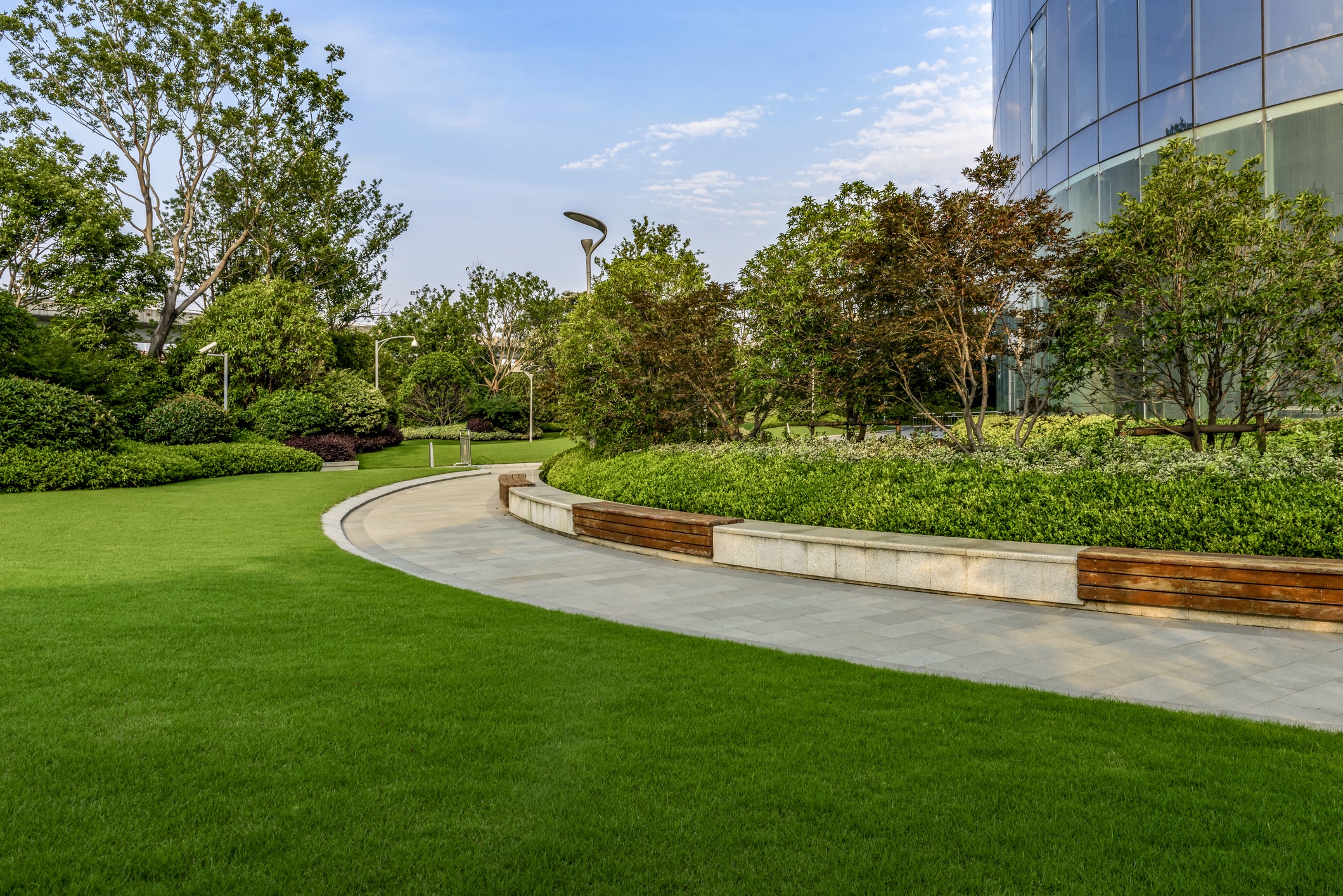 Modern building surrounded by lush green garden path